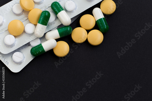 Pharmacy background on a black table. Tablets on a black background, pills. Medicine and healthy, close up of capsules.