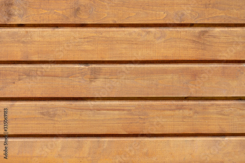the empty wooden background is dark orange. The boards are positioned horizontally. Knots on the wood surface.