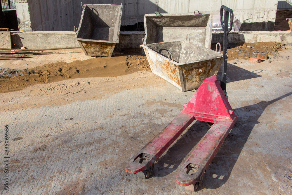 Hand pallet truck red at a construction site. Lifting equipment