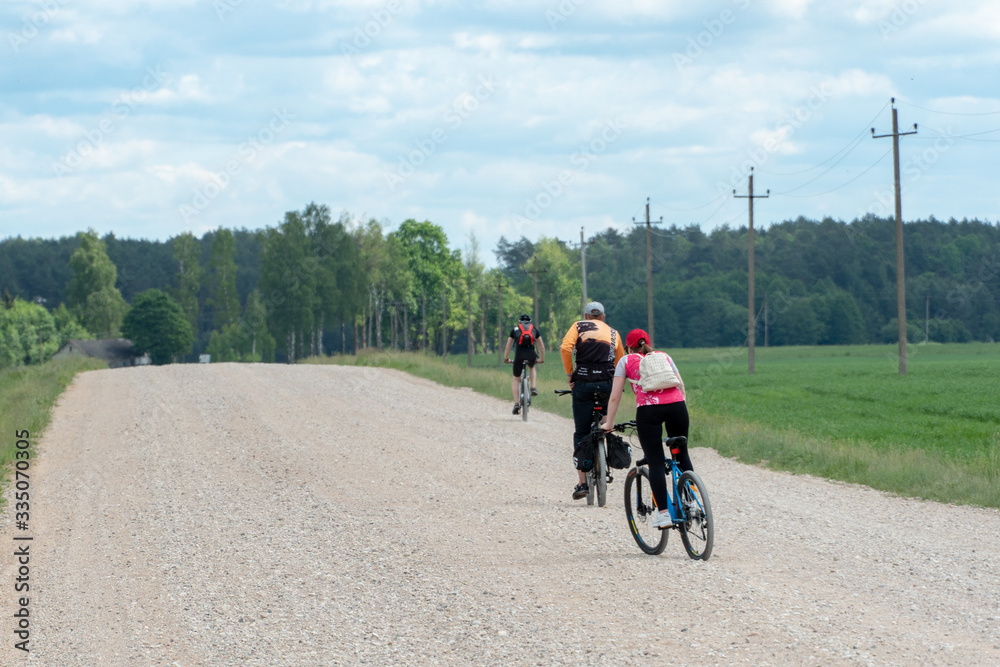 Grodno, Belarus, June 01.2019: Cycle tourism. Active rest on the nature. Travel by Bicycle. Weekend in the country. Two cyclists on a dirt road. Healthy lifestyle.