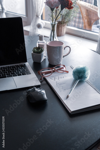 Working from home concept with  a laptop keypad with coffee cup, mouse and notepad with workfrom home written on a dining table © joisbalu