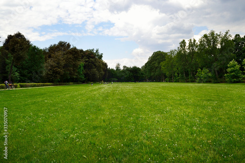 Firenze, Le Cascine park. A wide green meadow surrounded by trees