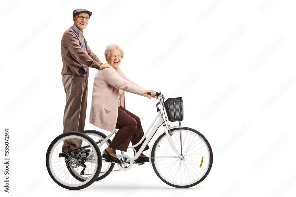 Senior man and woman riding on a tricycle Senior man and woman riding on a tricycle