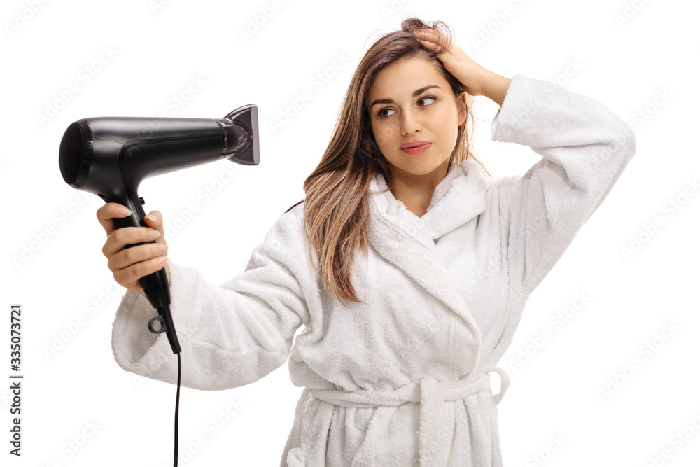 Young woman in a bathrobe blowdrying her hair Young woman in a bathrobe blowdrying her hair