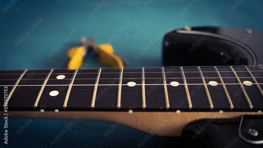 Fototapeta premium changing strings to black electric guitar