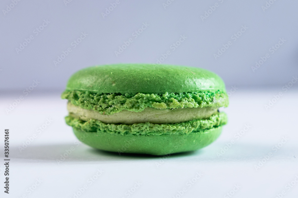 green macaroni cake with pistachio flavor and cream on a white background green macaroni cake with pistachio flavor and cream on a white background