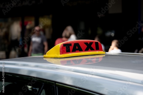 Detail of a TAXI sign on a roof of silver car in Fort William, Scotland