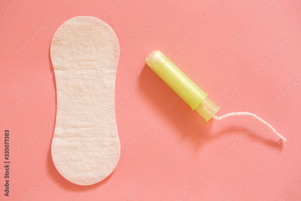 Menstrual cycle. White female pad and tampons on a pink background. Menstrual cycle. White female pad and tampons on a pink background.