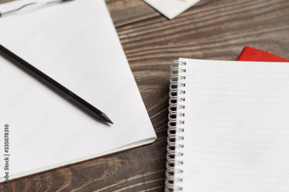 Close-up of a black tablet with a sheet of notepads and glasses with coffee on a wooden table with a blurred background. office Desk concept. Close-up of a black tablet with a sheet of notepads and glasses with coffee on a wooden table with a blurred background. office Desk concept.