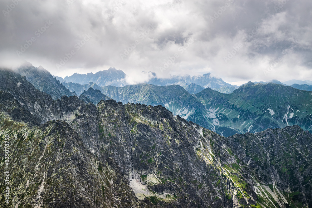 View onto the rugged mountain range of High Tatras seen from the peak of Jahňací štít down on an overcast, summer day. Scenic Slovakian Tatra landscape.