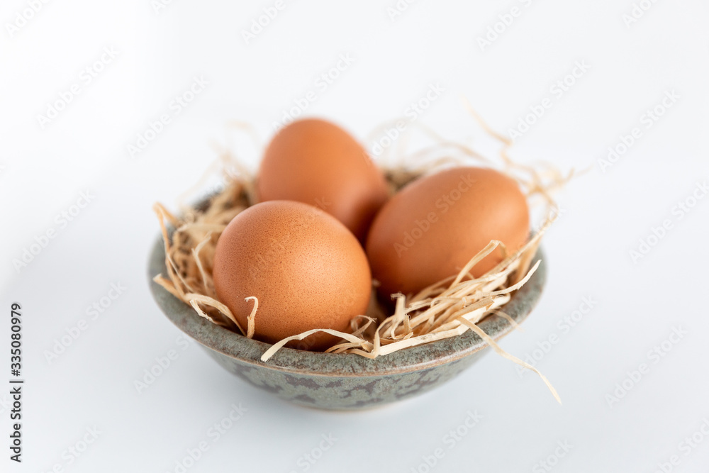 Drei Bio Eier im Osternest mit Heu Drei Bio Eier im Osternest mit Heu