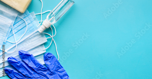 Means of protection against coronavirus - hand sanitizer spray, antibacterial soap, face surgical masks and latex gloves for main protective measures against coronavirus COVID-19. Top view, copy space