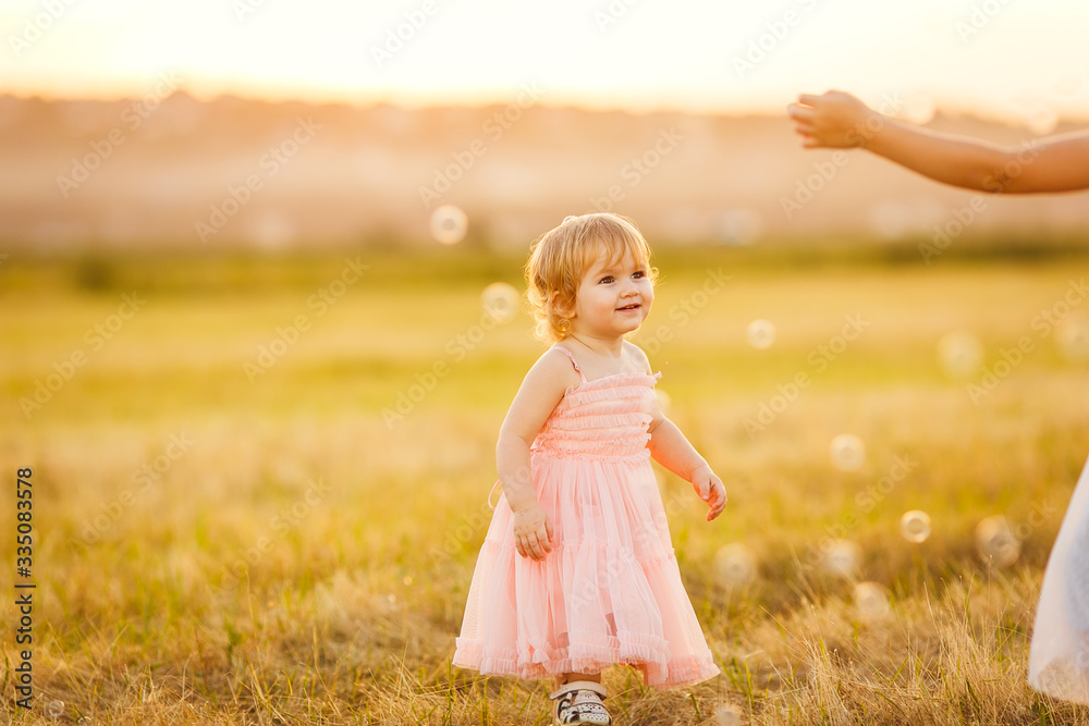 little girl chasing soap bubbles on sunset little girl chasing soap bubbles on sunset