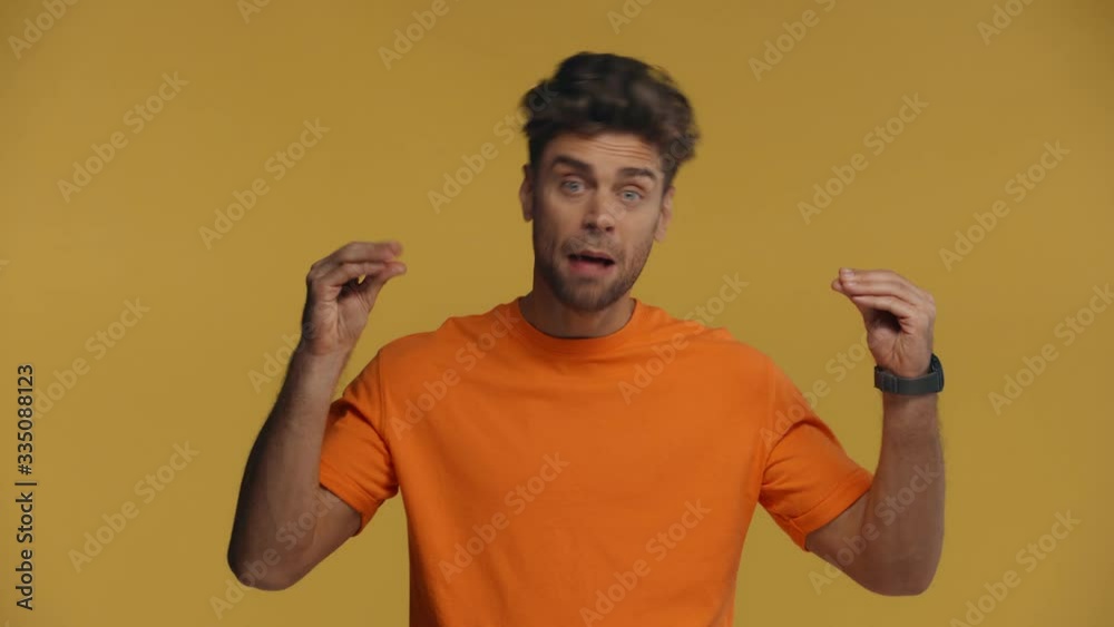 Skeptical man gesturing at camera isolated on yellow Skeptical man gesturing at camera isolated on yellow