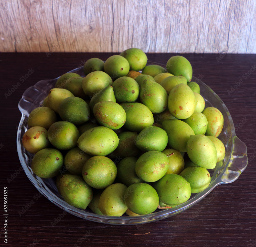 glass bowl filled with umbu fruit on a dark wooden background
glass bowl filled with umbu fruit on a dark wooden background
