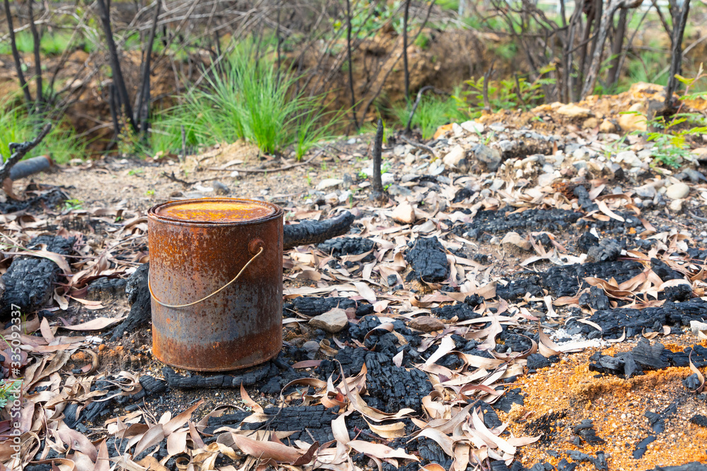 A burnt paint can in the forest from the bush fires in Australia A burnt paint can in the forest from the bush fires in Australia