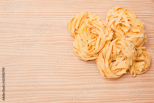 itallian fettuccine on a wooden background. recipe for homemade pasta