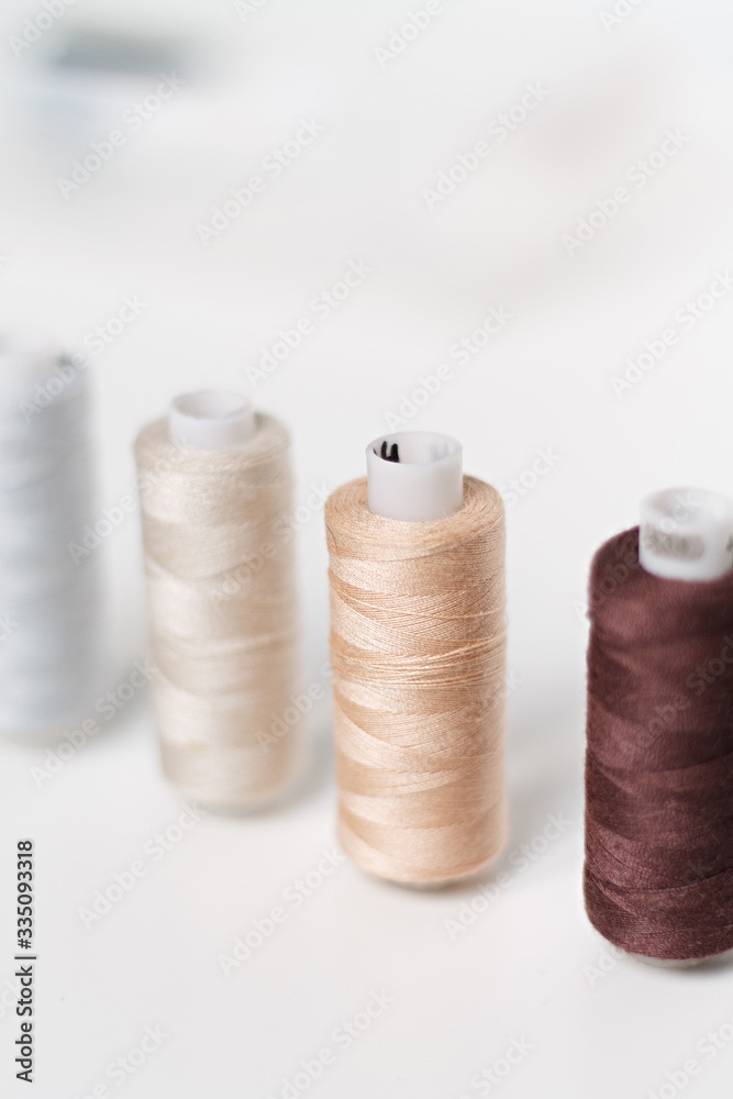 close-up of colored sewing threads on a light background with a place for the inscription. close-up of colored sewing threads on a light background with a place for the inscription.