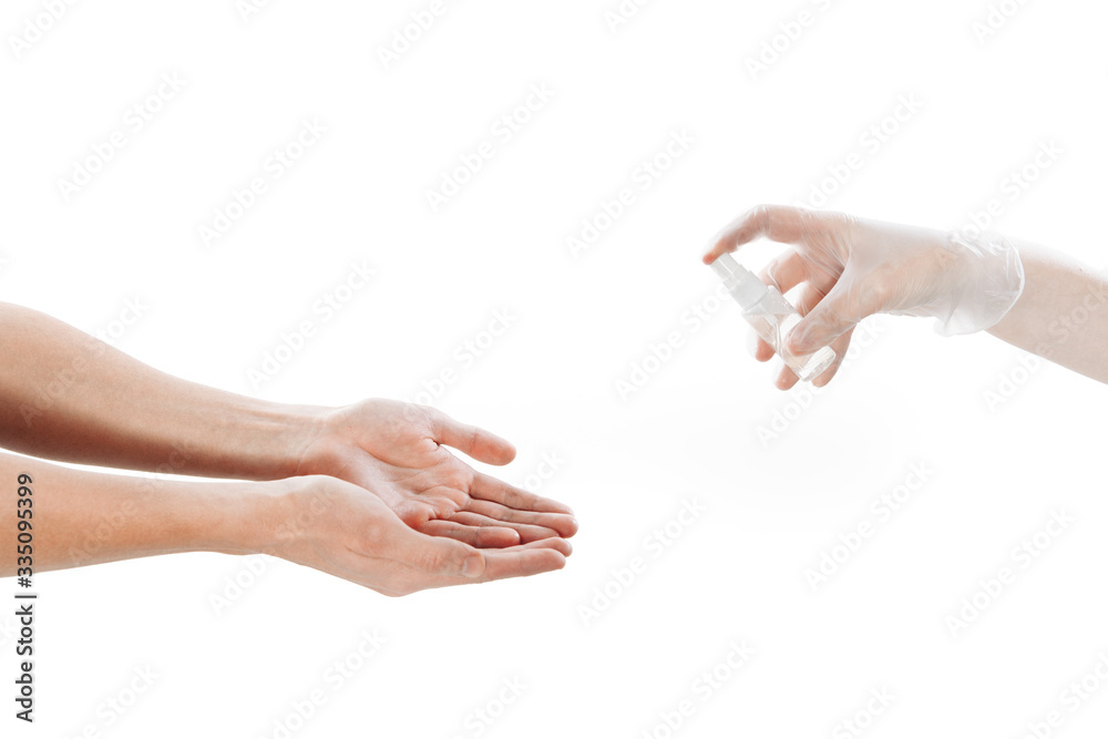 Disinfection of the hands. The palms are disinfected from a can. A hand in a transparent latex glove holds an antiseptic. Photo on a white background. Disinfection of the hands. The palms are disinfected from a can. A hand in a transparent latex glove holds an antiseptic. Photo on a white background.