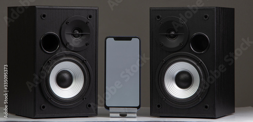 speaker with smartphone on grey background photo
