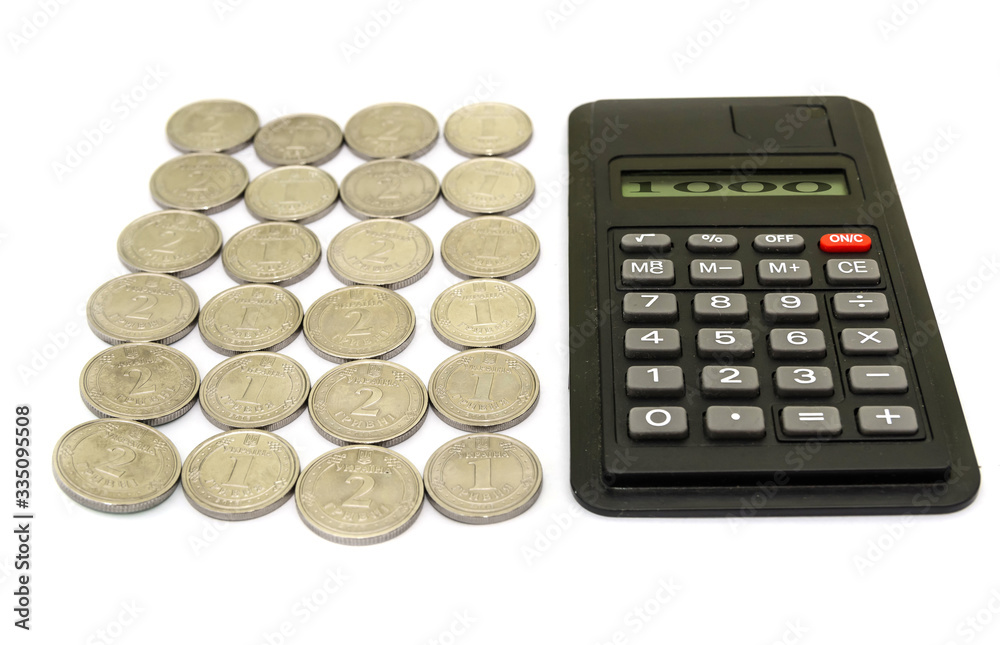 Ukrainian coins and calculator on white. number 1000 on the scoreboard. Business concept. Ukrainian coins and calculator on white. number 1000 on the scoreboard. Business concept.
