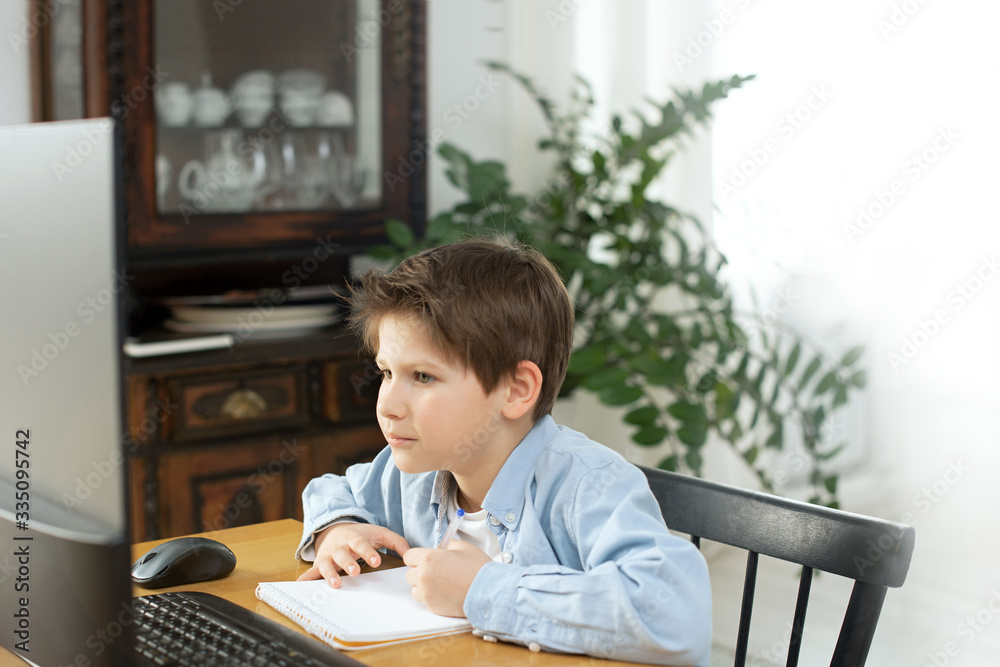 Distance learning during isolation during quarantine in coronovirus. Boy and laptop at home. Lifestyle Distance learning during isolation during quarantine in coronovirus. Boy and laptop at home. Lifestyle