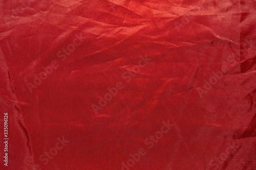 Top view of crumpled red fabric, abstract scarlet background.
