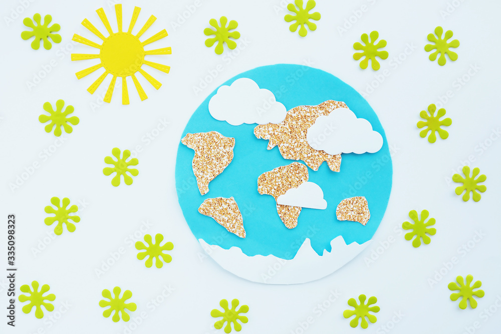 Naklejka premium paper application: planet Earth, continents, clouds, sun and green viruses around on a white background. Coronavirus pandemic concept.