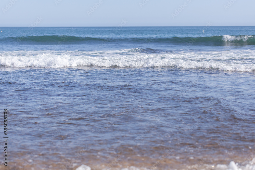 Água do mar formando ondas perto da praia