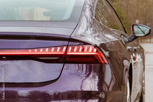 Premium LED sedan taillights. The car is purple in the street. close-up