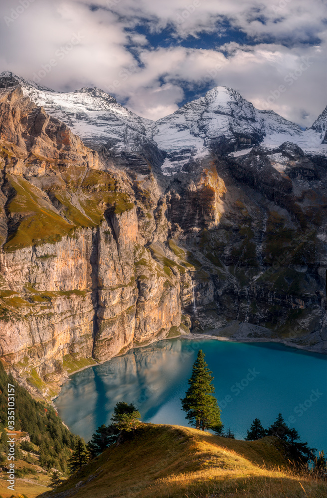 Scenic top view of Oeschinensee, Oeschinen Lake by Kandersteg, Switzerland. High mountains and rocks in background. Swiss Alps.