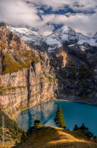 Scenic top view of Oeschinensee, Oeschinen Lake by Kandersteg, Switzerland. High mountains and rocks in background. Swiss Alps.