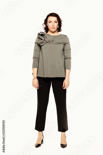 Full length of serious woman in a gray blouse, isolated on white background