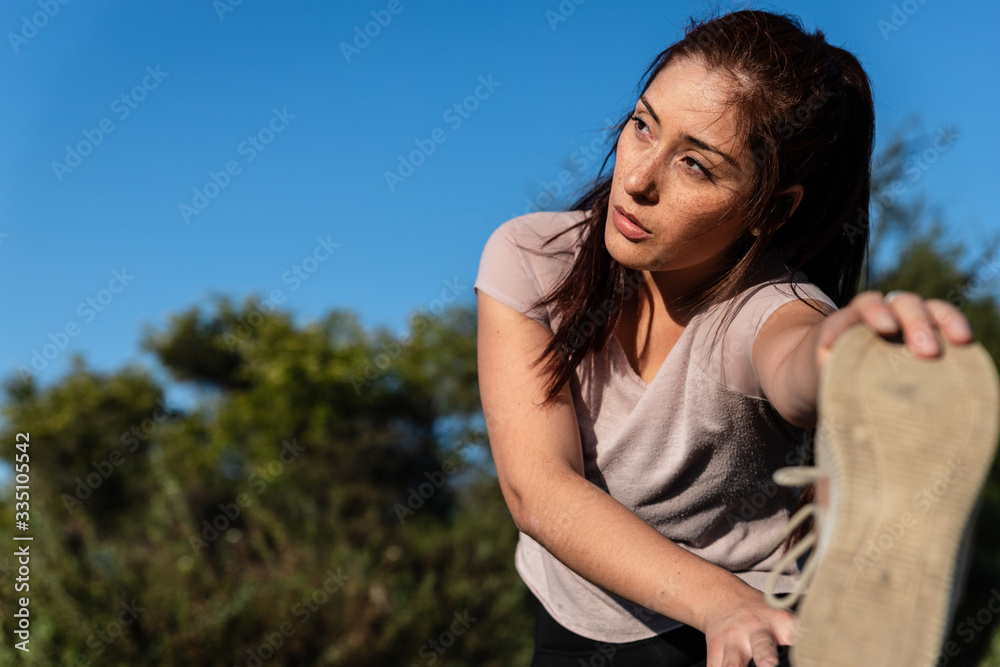 beautiful caucasian young woman doing sports and stretching outdoors in the park beautiful caucasian young woman doing sports and stretching outdoors in the park
