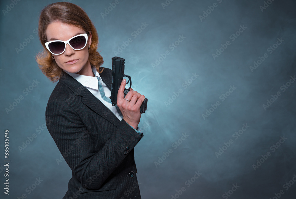 Portrait of woman with gun on blue background Portrait of woman with gun on blue background