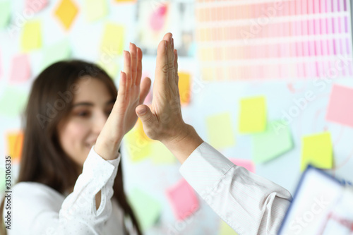 Excited workers in office crossed arms in pile for win close-up. White collar leadership by giving joint high five or corporate lifestyle friendship deal heap stack concept