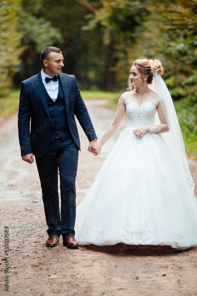 Bride and groom in a park kissing.couple newlyweds bride and groom at a wedding in nature green forest are kissing photo portrait.Wedding Couple Bride and groom in a park kissing.couple newlyweds bride and groom at a wedding in nature green forest are kissing photo portrait.Wedding Couple