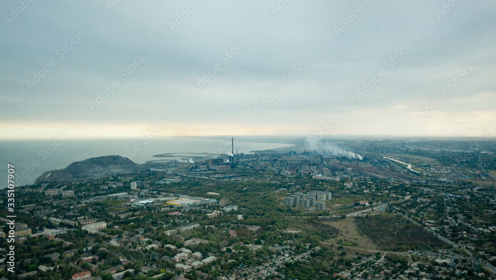 Industrial city in summer. On the horizon, a metallurgical plant near the sea. Aerial view. Mariupol, Ukraine