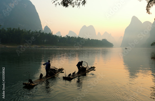 Silhouette of Fishing Men and His Cormorants on Li River at Sunrise, Guilin, China. The Li River or Lijiang is a river in Guangxi Zhuang Autonomous Region, China.