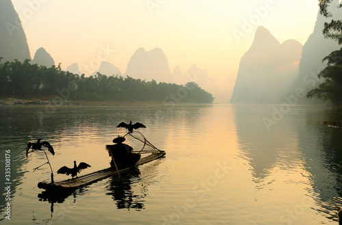 Silhouette of Fishing Men and His Cormorants on Li River at Sunrise, Guilin, China. The Li River or Lijiang is a river in Guangxi Zhuang Autonomous Region, China.