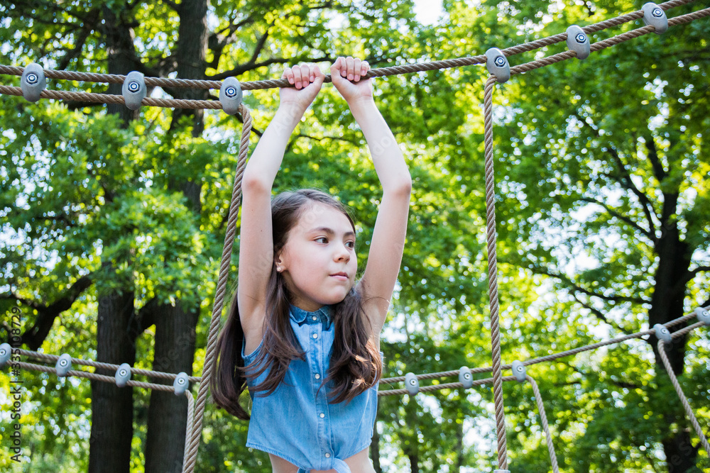 portrait of girl playing on playground in park in summer time. summer vacation portrait of girl playing on playground in park in summer time. summer vacation