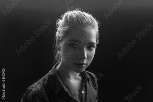 Black and white closeup portrait of young pretty sensual girl in checkered shirt posing tilting her head. her hair is gathered behind and backlit  her eyes are summed up with mascara. model tests