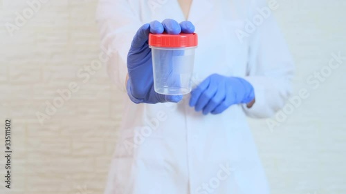 Doctor showing empty container for urine sample for analysis and research in medical laboratory, medical urine test and health scanning, drug test concept.