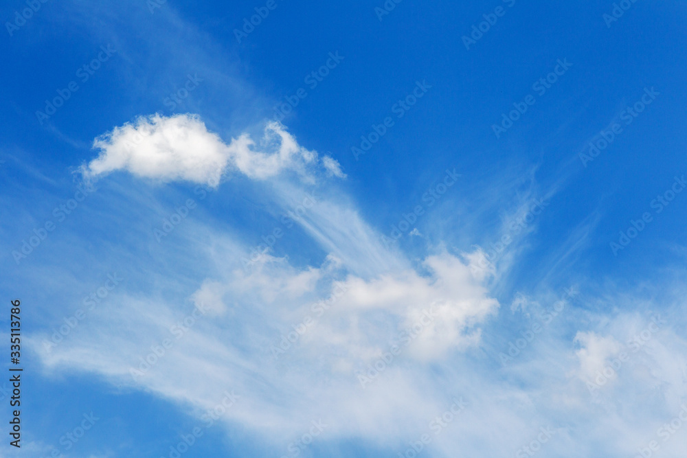 Big bright unusual beautiful sky with white creative clouds. Blue sky with unusual cumulus fluffy clouds as a natural background for design