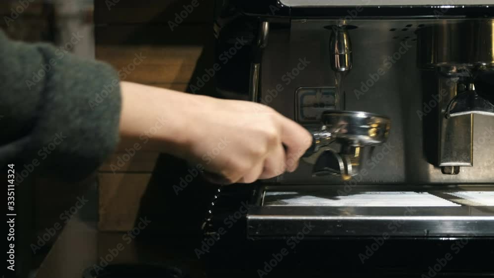 Medium close up of hand washing holder under the water jet of coffee machine Medium close up of hand washing holder under the water jet of coffee machine