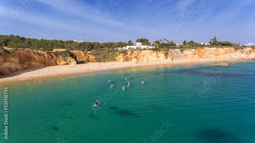 Young people in a practical surfing lesson, stand on the boards with oars. Portugal Algarve. © sergojpg