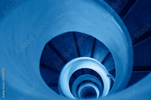 Fotografie Old stairs in spiral staircase toned in classic blue - color of the year 2020