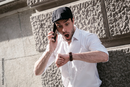 Εκτύπωση καμβά Single stylish male having conversation on his cellphone and shocked looking on