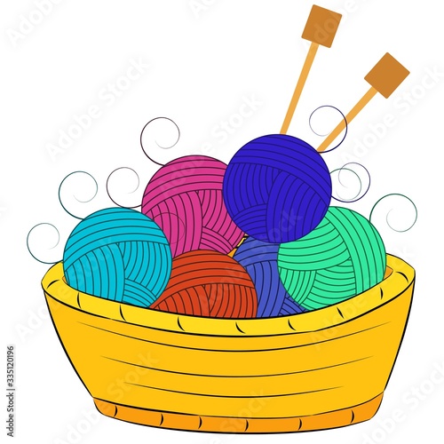 Balls of wool and knitting needles lie in a basket.