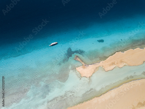 Aerial view of a boat in the red sea and sand island, Egypt